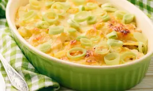 Ein köstlicher, schneller Auflauf mit Lachs und Kartoffeln, überbacken mit Käse und garniert mit Lauchringen.