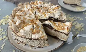 Eine himmelstorte mit kirschen, verziert mit Mandelblättchen, wartet darauf, angeschnitten zu werden.