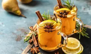Zwei Gläser mit einem warmen Hot Toddy Rezept, garniert mit Zimt, Sternanis, Zitrone und Birne.