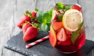 Erfrischende alkoholfreie Erdbeerbowle mit frischen Erdbeeren, Zitrone und Minze in einem Glas.