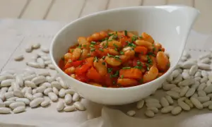 Schmackhafte weiße Bohnen in Tomatensoße, garniert mit Schnittlauch. Die Frage "wie lange bohnen kochen" wird hier visuell beantwortet.