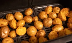 Kleine, goldbraune Kartoffeln, die in einem Airfryer zubereitet werden. Sie sehen aus, als wären sie perfekt zum Servieren, wenn die Drillinge kochen.
