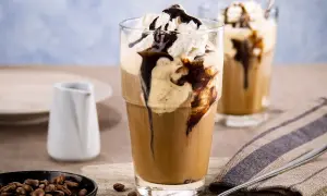 Ein erfrischender Eiskaffee mit Vanilleeis, garniert mit Sahne und Schokoladensauce. Perfekt für einen warmen Tag.