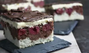 Schokoladen-Kirsch-Torte mit weißer Creme und Schokoglasur. Diese veganen Kuchen sind ein Genuss!