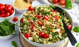 Ein bunter Nudelsalat mit Kirschtomaten, Rucola und Pinienkernen – perfekt für leichte sommergerichte abendessen.