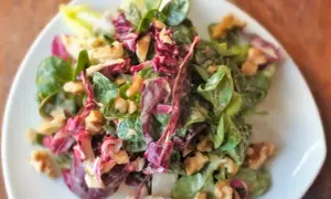 Frischer Feldsalat mit Radicchio und Walnüssen, verfeinert mit einem cremigen Kartoffeldressing.