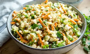 Bunter Hirse Salat mit Kichererbsen, Karottenstreifen und Pinienkernen. Ein leichter und gesunder Genuss.