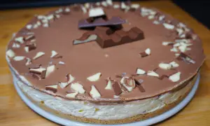 Eine köstliche Kinderriegel Torte mit Schokoladenglasur und gehackten Kinderriegeln verziert.