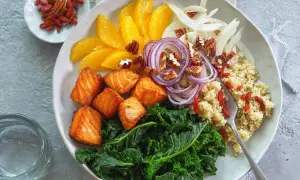 Gesunde Bowl-Rezepte: Lachs, Grünkohl, Quinoa, Orange, Fenchel, rote Zwiebeln, Pekannüsse und Goji-Beeren.