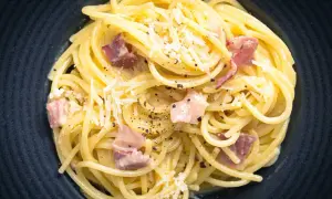 Spaghetti Carbonara mit Speck und Parmesan, ein Gericht, das leicht misslingt. Vermeiden Sie 10 Fehler beim Pasta kochen für perfekten Genuss.