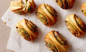 Herzhafte Snacks aus fertigem Pizzateig: Gerollte Teigschnecken mit Kräuterfüllung, perfekt für schnelle Rezepte.
