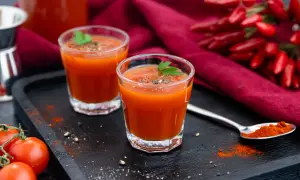 Zwei Gläser scharfer Tomatensaft, perfekt für ein mexikaner rezept. Mit frischen Tomaten und Chilis garniert.