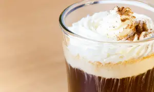 Ein erfrischender Eiskaffee mit Sahne und Zimt bestreut, perfekt für einen warmen Tag.