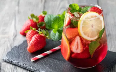 Erfrischende alkoholfreie Erdbeerbowle mit frischen Erdbeeren, Zitrone und Minze in einem Glas.