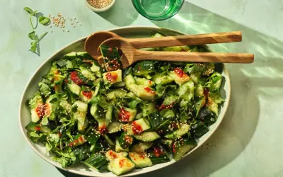Erfrischender smashed Gurkensalat mit Koriander, Sesam und einer würzigen Sauce. Perfekt als Beilage oder leichter Snack.
