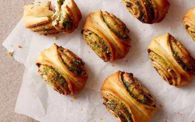 Herzhafte Snacks aus fertigem Pizzateig: Gerollte Teigschnecken mit Kräuterfüllung, perfekt für schnelle Rezepte.