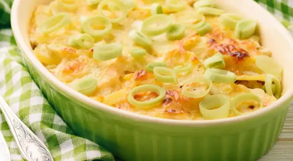 Ein köstlicher, schneller Auflauf mit Lachs und Kartoffeln, überbacken mit Käse und garniert mit Lauchringen.