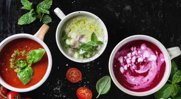 Erfrischendes Essen bei warmen Wetter: Drei bunte Suppen – Tomate, Gurke und Rote Bete – mit frischen Kräutern und Gemüse.