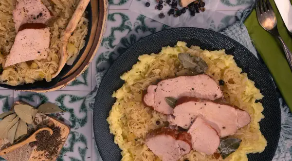 Omas Sauerkraut mit zartem Schweinebraten und Kartoffelpüree. Ein deftiges Gericht, das an Zuhause erinnert.