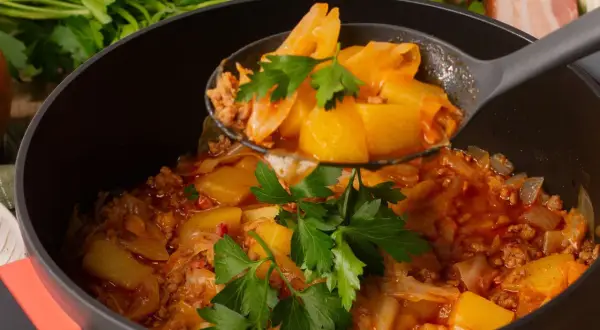 Schichtkohl nach Omas Rezept: herzhaftes Gericht mit Kohl, Hackfleisch und Kartoffeln, garniert mit Petersilie.