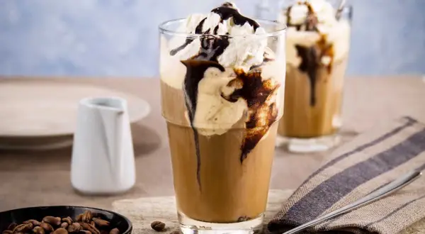 Ein erfrischender Eiskaffee mit Vanilleeis, garniert mit Sahne und Schokoladensauce. Perfekt für einen warmen Tag.