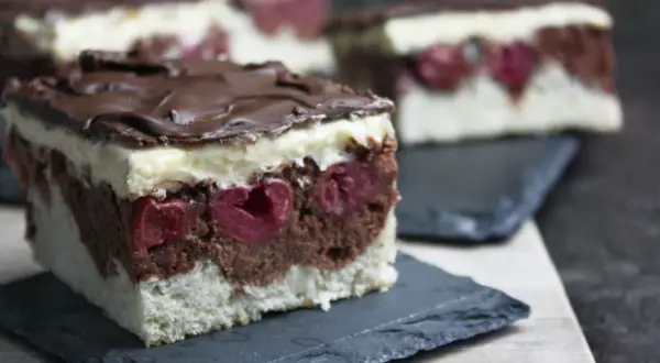 Schokoladen-Kirsch-Torte mit weißer Creme und Schokoglasur. Diese veganen Kuchen sind ein Genuss!