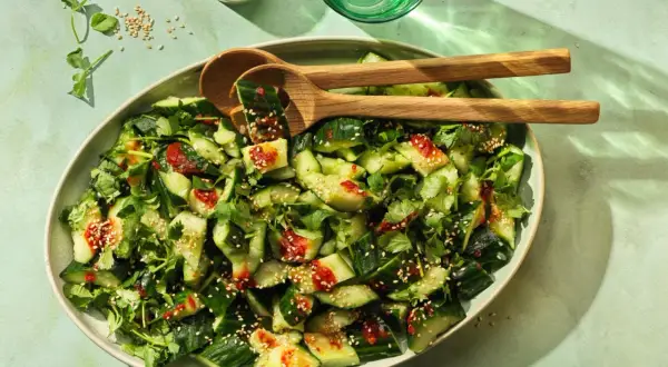 Erfrischender smashed Gurkensalat mit Koriander, Sesam und einer würzigen Sauce. Perfekt als Beilage oder leichter Snack.