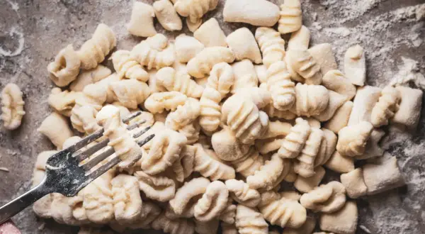 Frische Gnocchi, bereit für köstliche Gnocchi Rezepte, werden mit einer Gabel geformt.