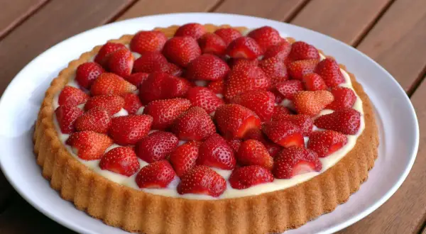 Ein köstlicher Obstboden mit Biskuitboden, gefüllt mit Vanillecreme und belegt mit frischen Erdbeeren. Ein perfektes Rezept für den Sommer.