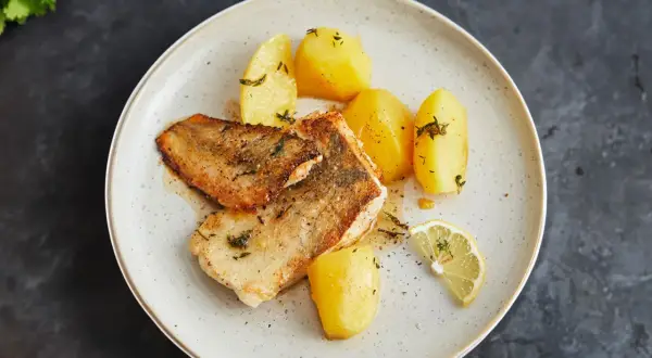 Gebratene Fischfilets mit Salzkartoffeln und Zitrone – so einfach lässt sich eine köstliche Fischplatte selber machen.