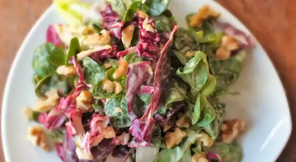 Frischer Feldsalat mit Radicchio und Walnüssen, verfeinert mit einem cremigen Kartoffeldressing.
