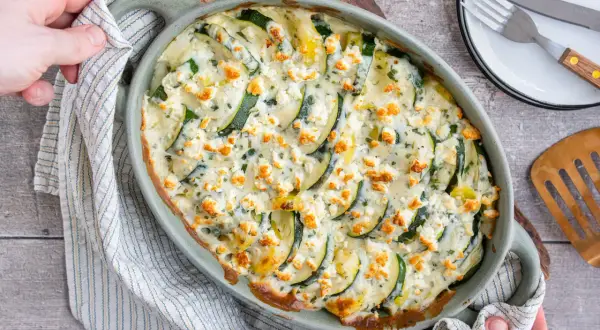 Ein köstlicher Zucchini Kartoffel Feta Auflauf, goldbraun gebacken und mit Kräutern bestreut. Perfekt für ein leichtes Abendessen.