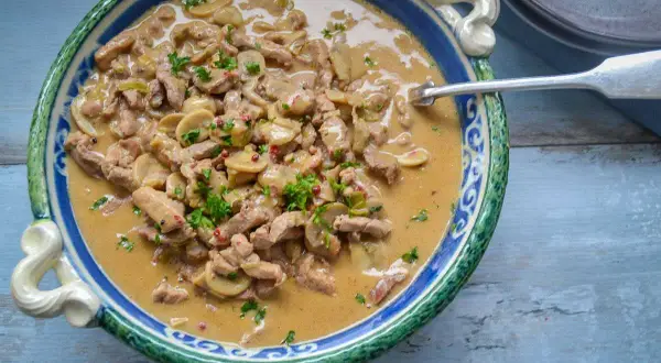 Herzhaftes Schweinegeschnetzeltes mit Pilzen in cremiger Soße, garniert mit Petersilie. Ein köstliches Schweinegeschnetzeltes Rezept!