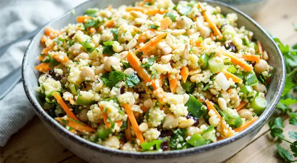 Bunter Hirse Salat mit Kichererbsen, Karottenstreifen und Pinienkernen. Ein leichter und gesunder Genuss.