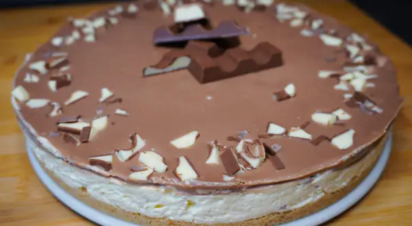 Eine köstliche Kinderriegel Torte mit Schokoladenglasur und gehackten Kinderriegeln verziert.