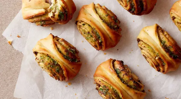Herzhafte Snacks aus fertigem Pizzateig: Gerollte Teigschnecken mit Kräuterfüllung, perfekt für schnelle Rezepte.