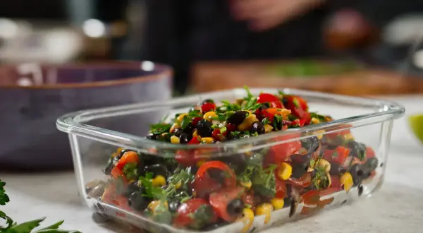 Frischer Bohnensalat mit Tomaten, Mais und Kräutern in einer Glasbox, perfekt für gesunde Bohnensalat Rezepte.