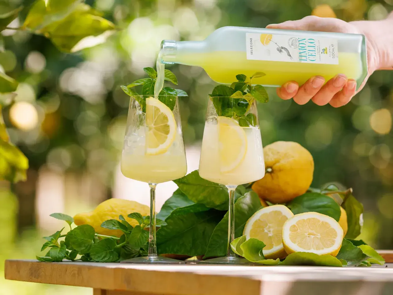 Limoncello wie trinken? Ein erfrischender Drink mit Zitrone und Minze wird in Gläser gegossen.