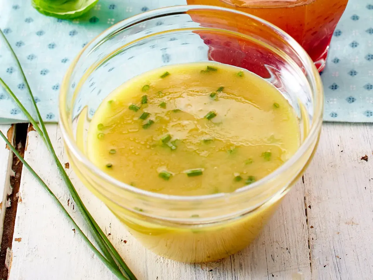 Ein Glas mit cremigem honig senf dressing, garniert mit Schnittlauch. Perfekt für Salate!