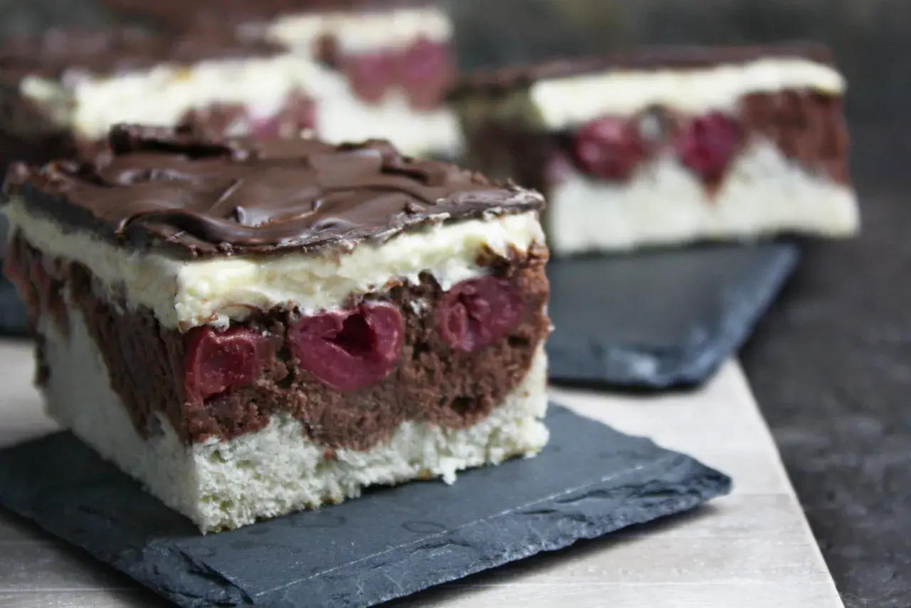 Schokoladen-Kirsch-Torte mit weißer Creme und Schokoglasur. Diese veganen Kuchen sind ein Genuss!