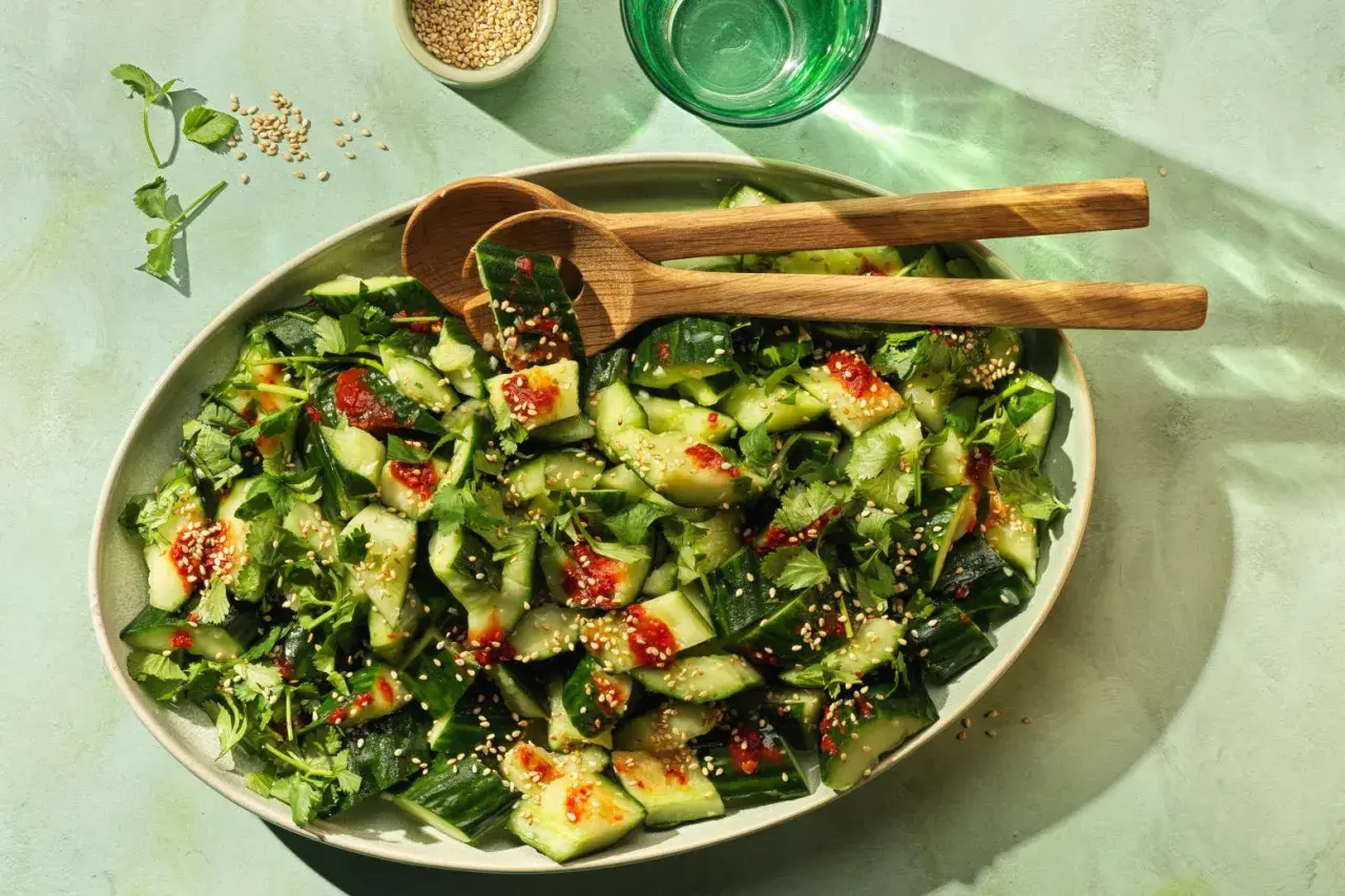 Erfrischender smashed Gurkensalat mit Koriander, Sesam und einer würzigen Sauce. Perfekt als Beilage oder leichter Snack.
