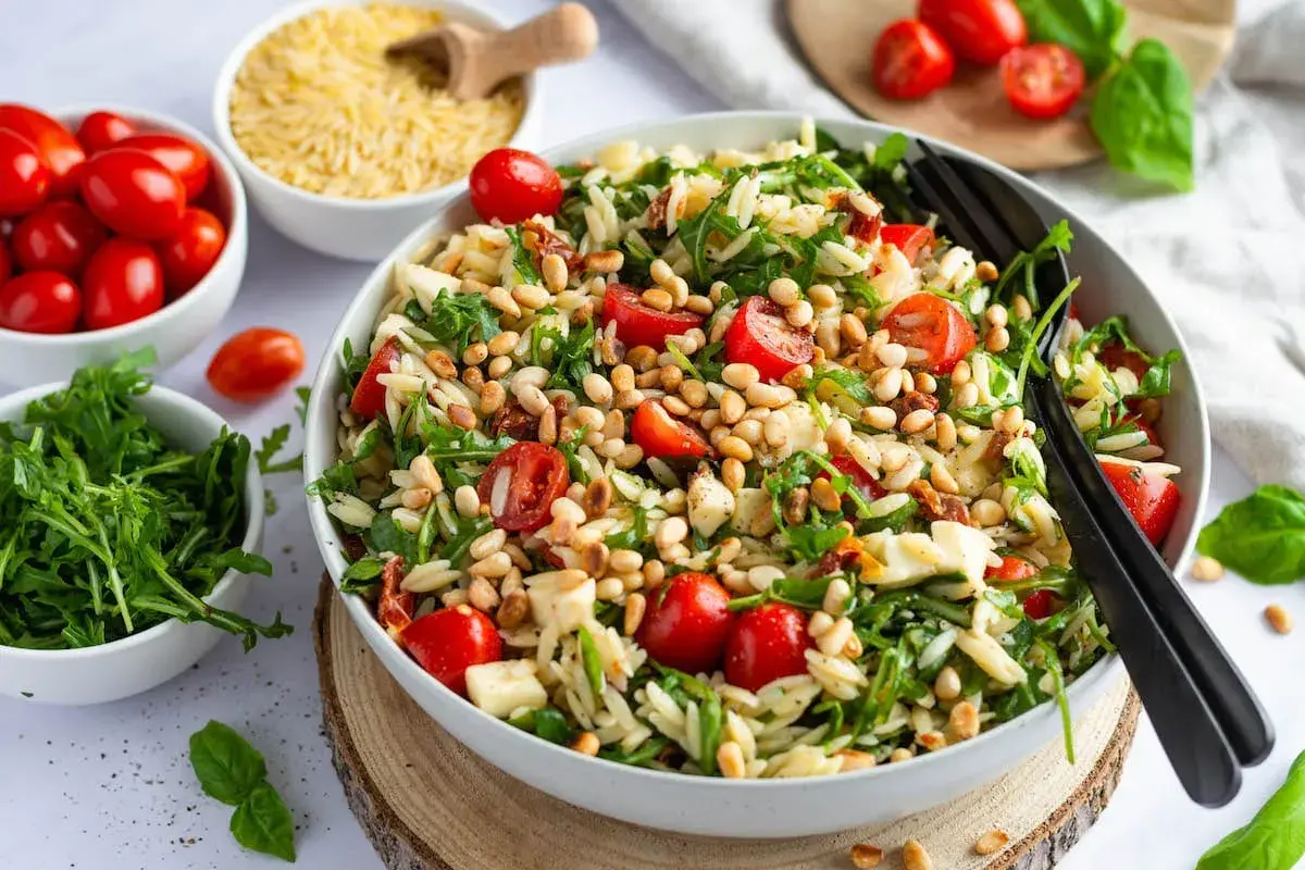Ein bunter Nudelsalat mit Kirschtomaten, Rucola und Pinienkernen – perfekt für leichte sommergerichte abendessen.