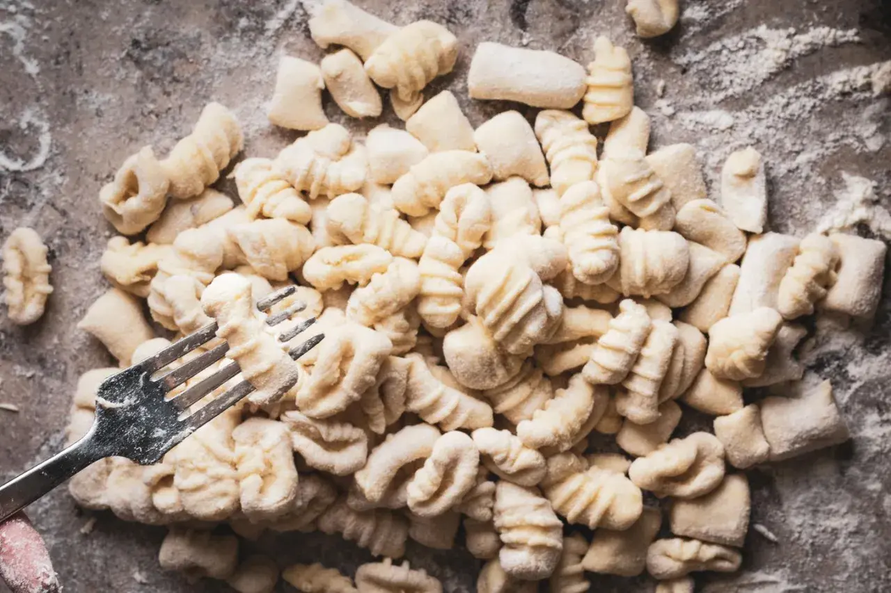 Frische Gnocchi, bereit für köstliche Gnocchi Rezepte, werden mit einer Gabel geformt.