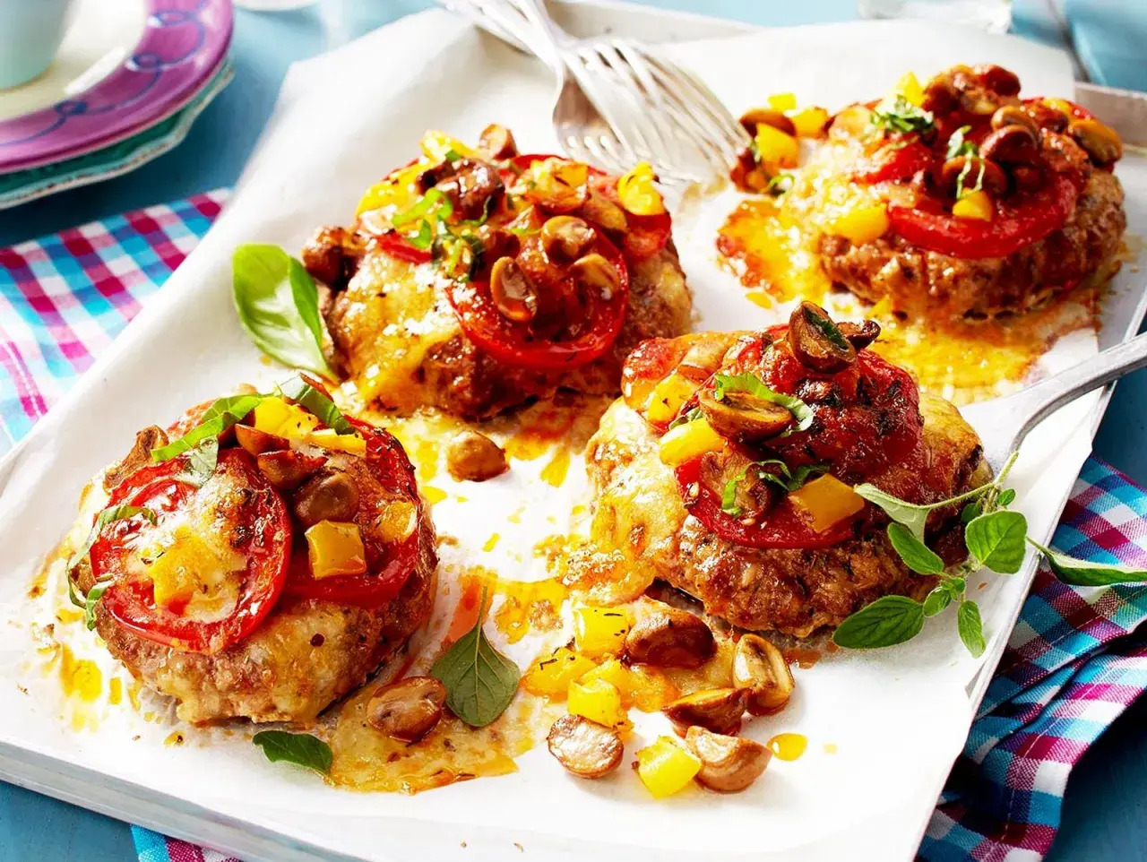 Vier Hackfleisch-Patties mit geschmolzenem Käse, Tomaten, Pilzen und Paprika. Perfekt für schnelle Hackfleisch Rezepte!