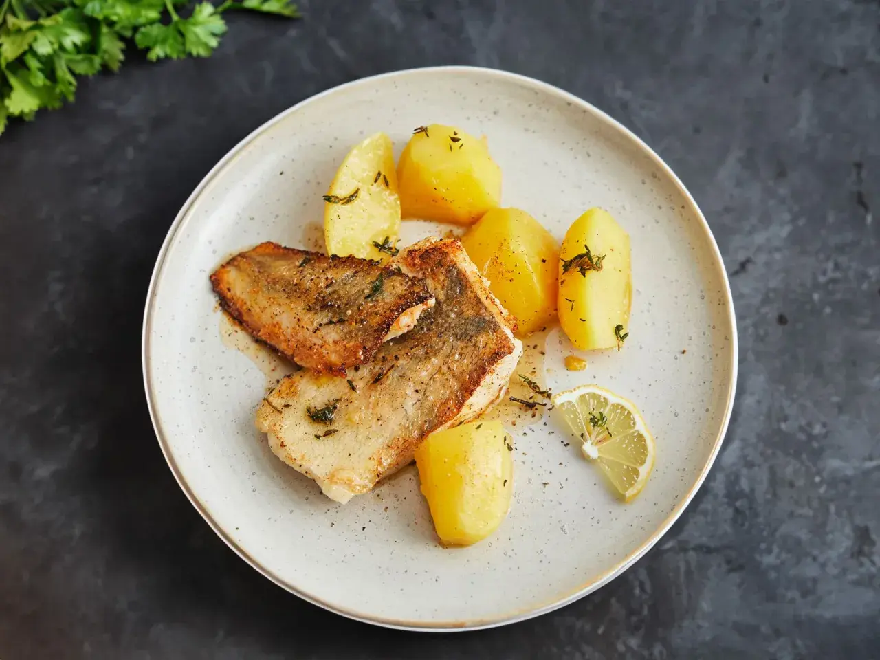 Gebratene Fischfilets mit Salzkartoffeln und Zitrone – so einfach lässt sich eine köstliche Fischplatte selber machen.