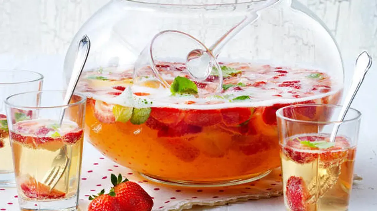 Erfrischendes Bowle-Rezept mit Erdbeeren und Minze in einer großen Glasbowle, bereit zum Servieren in Gläsern.