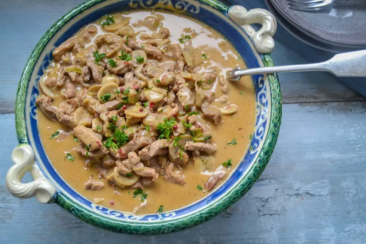 Herzhaftes Schweinegeschnetzeltes mit Pilzen in cremiger Soße, garniert mit Petersilie. Ein köstliches Schweinegeschnetzeltes Rezept!