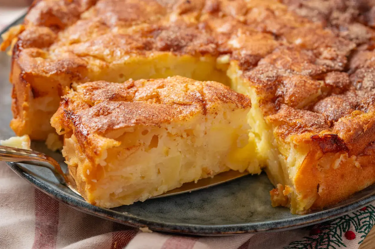 Ein saftiger Apfelkuchen aus der Springform, mit Zimt bestreut und gerade angeschnitten.