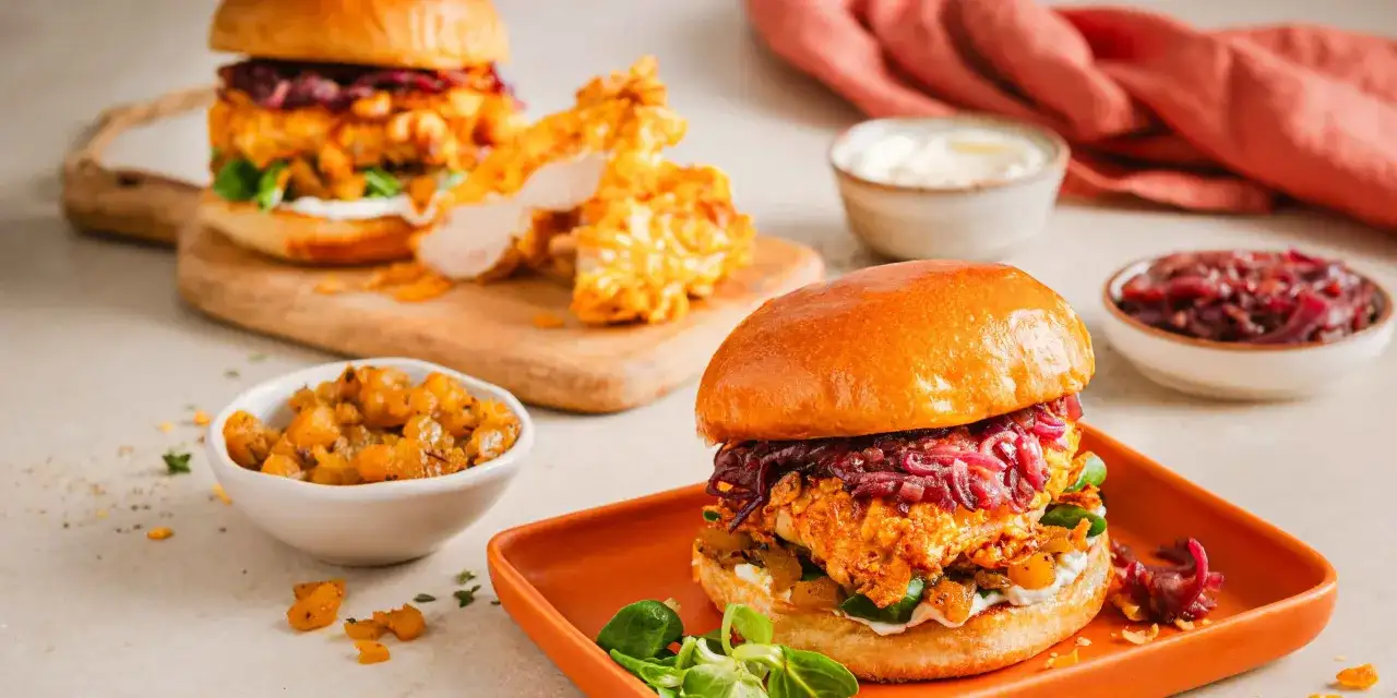 Saftige Burger mit knusprigem Hähnchen, perfekt für Airfryer Rezepte. Dazu gibt es karamellisierte Zwiebeln und eine cremige Sauce.