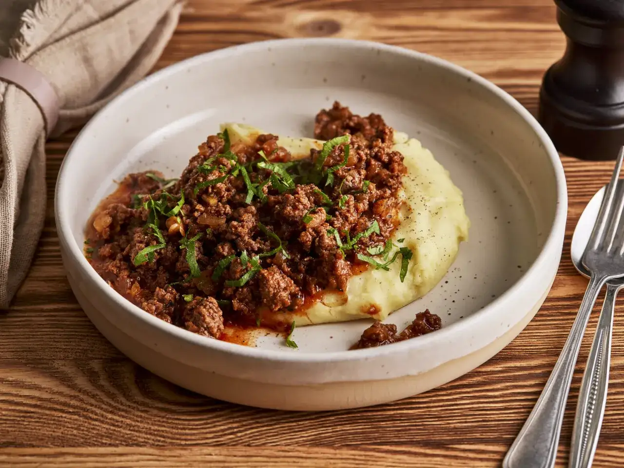 Herzhaftes Haschee-Rezept von Oma: Hackfleisch mit Kartoffelp&uuml;ree, garniert mit Petersilie, auf einem Teller.